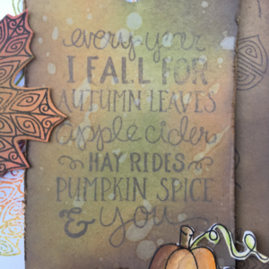 Closeup of tag for fall card that as been stamped with Newton Nook stamps and the background created with Ranger oxide inks.