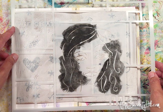 Stenciling a female head using paint into an art journal.
