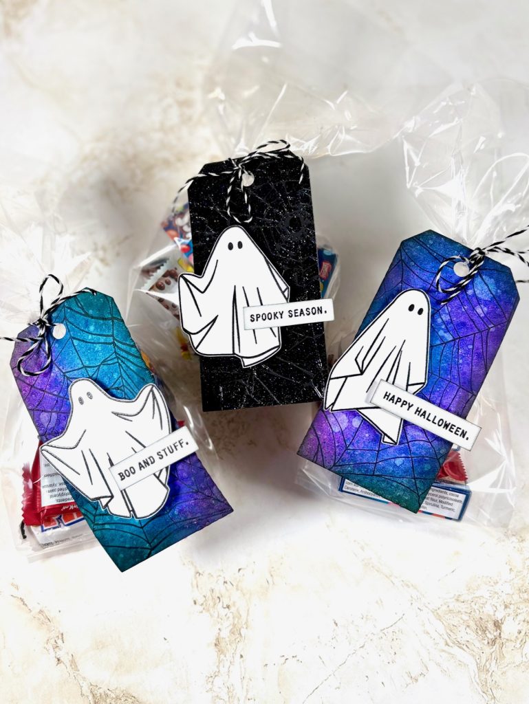Handmade spooky treat tags by Heather Fischer featuring ghost stamps from Stampers Anonymous and colorful Ranger Distress backgrounds tied to Halloween candy bags.